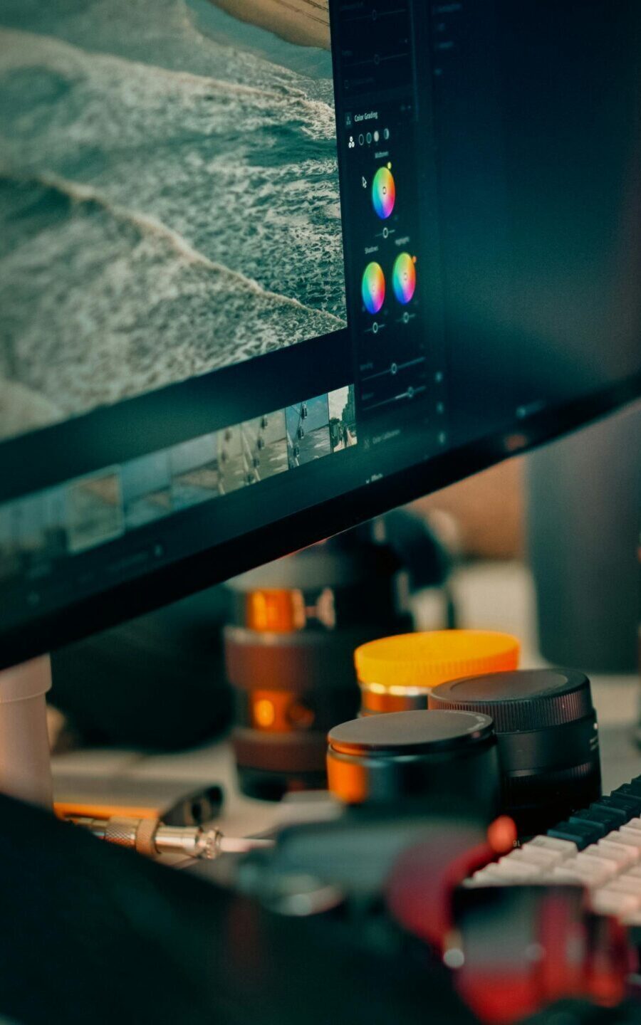 A digital editing workspace showcasing a computer screen with photo editing software open, surrounded by camera equipment.